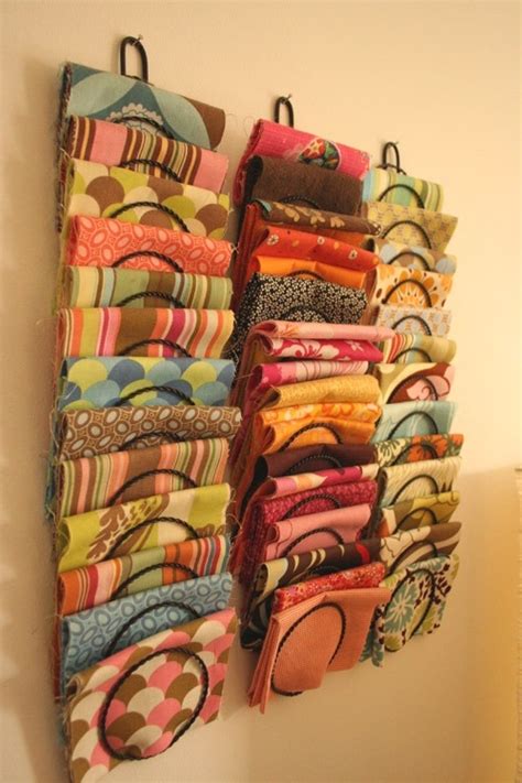 How to arrange scarves - Arrange scarves in geometric patterns on a wall, alternating colors and designs. Hang them on pegs or Command hooks for an artsy look. Roll up scarves and store in baskets, bins, or jars placed on shelves. Drape scarves over lamps, chairs, bedposts, or clothing racks. Group all scarves from the same team together in one area.